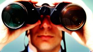 A man looks with a binoculars