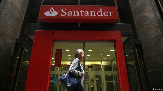 Una mujer pasa por la puerta de una sucursal del banco Santander en Brasil 140910100728_banco_santander_brasil_624x