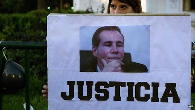 Una mujer sostiene una pancarta en reclamo de justicia por la muerte del fiscal en enero de 2015