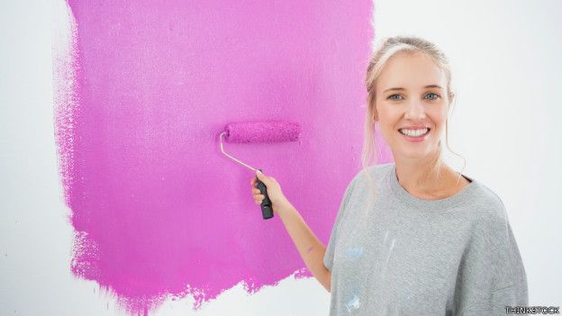 Una mujer pintando una pared