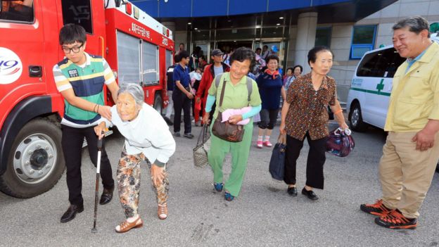 韓國東北部高城郡老年居民在工作人員攙扶下離開避難所（23/8/2015）