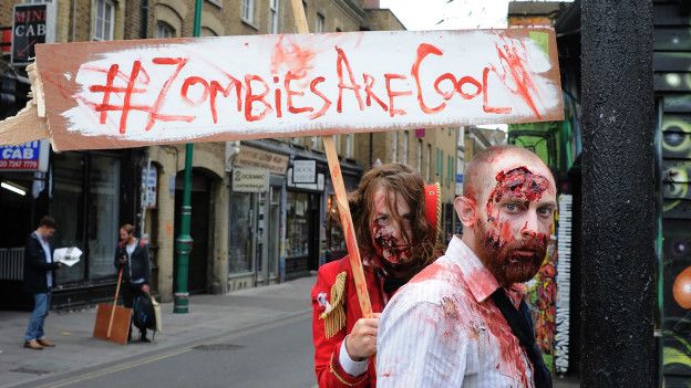 Personas disfrazadas de zombis caminan por las calles de Londres