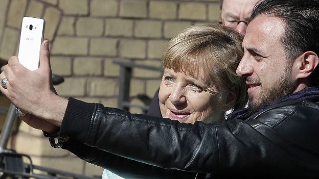 Беженец снимает селфи с Меркель