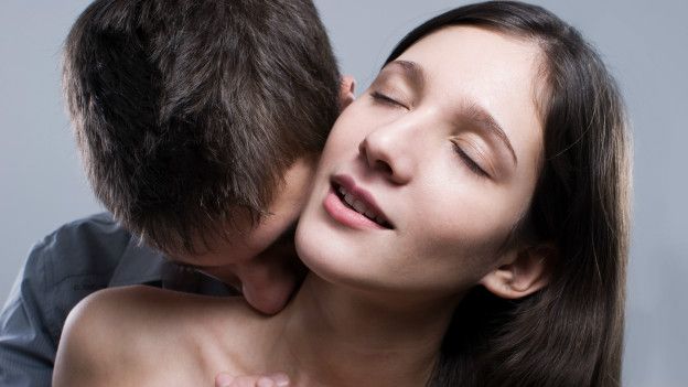 Un hombre besa sensualmente a una mujer
