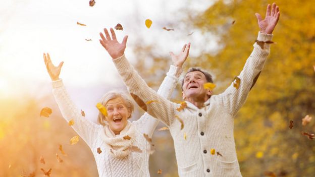 Dos adultos mayores celebrando al aire libre