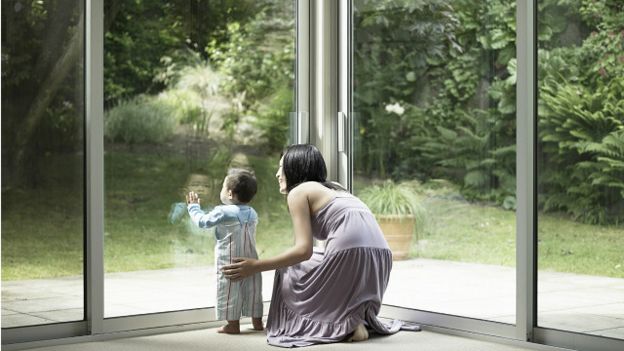 Madre con hijo mirando por la ventana