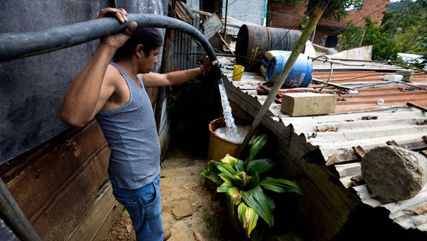 Hombre se abastece de agua en Caracas