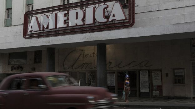 Mujer vestida de vedette frente al teatro America