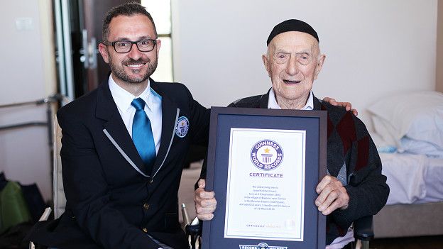 Israel Kristal sostiene la placa de reconocimiento del Récord Guinness