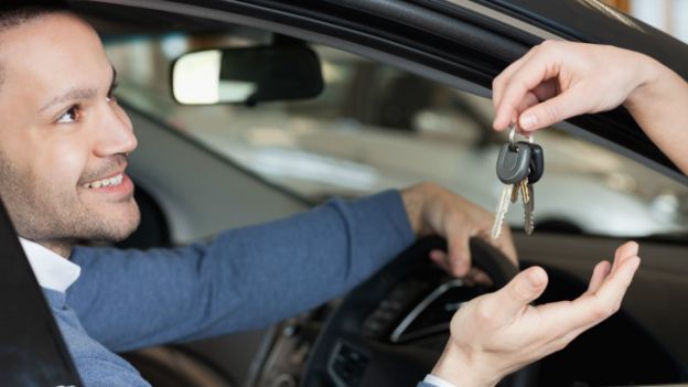 Una persona recibiendo las llaves de su auto