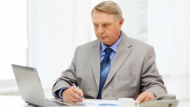 Пожилой бизнесмен перед ноутбуком