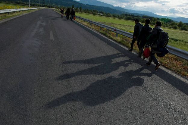 Мигранты идут по дороге рядом с границей Македонии
