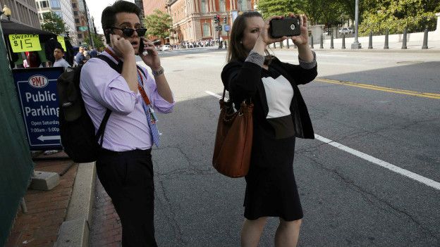 Прохожие снимают на свои телефоны происходящее вокруг Белого дома