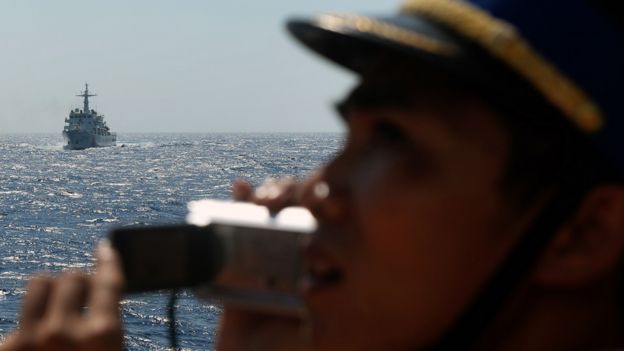 越南海警在船艇上监视远处的中国海监船（资料图片）