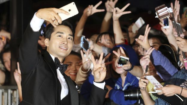 韩国演员宋承宪走红毯与粉丝自拍。