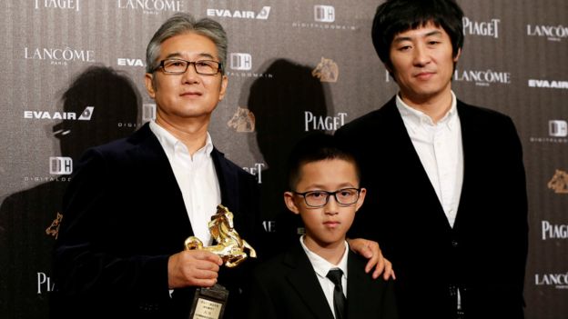 年仅10岁的孔维一（中）与他的父亲（左）及《八月》导演张大磊（右）出席金马奖。