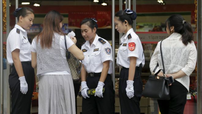天安门广场周边的民众在进入商店前接受安全检查。