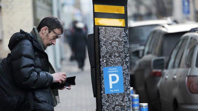 Мужчина платит за парковку