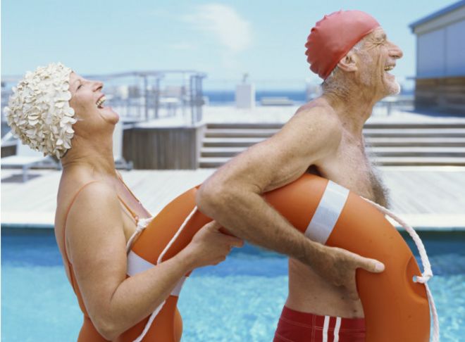 Dos adultos mayores celebrando en una piscina