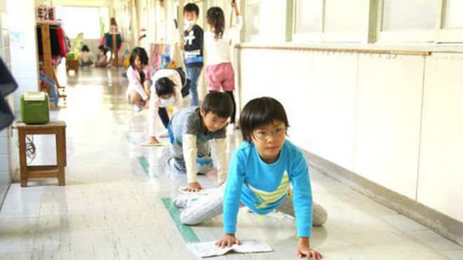 Niños escolares limpiando pisos en Japón