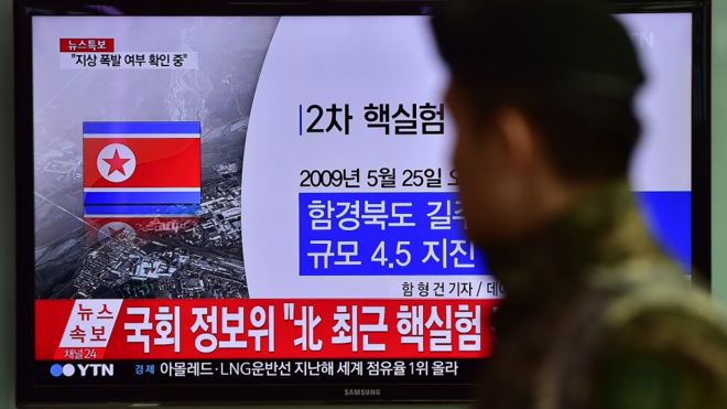 韩国民众行经播放朝鲜氢弹试射画面的电视墙。