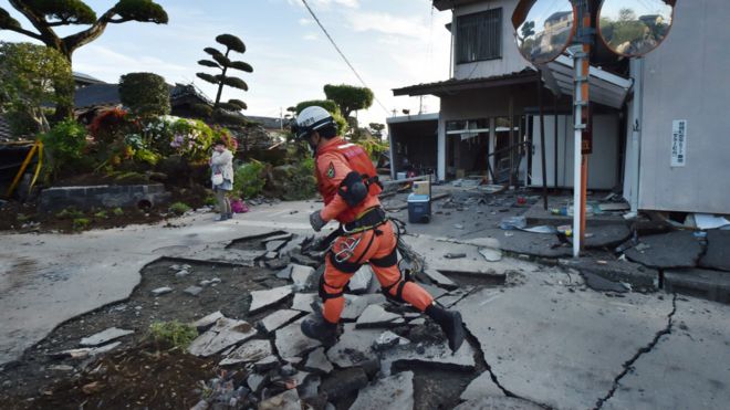 一名救援人员在受地震破坏的地面上跑过