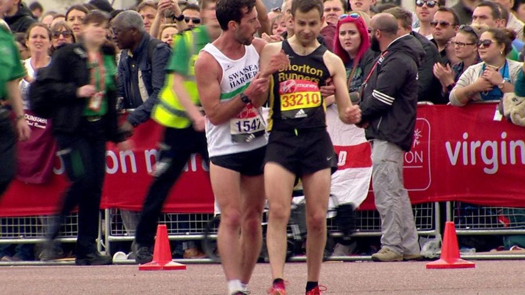 Exhausted London Marathon runner helped across the line - BBC News