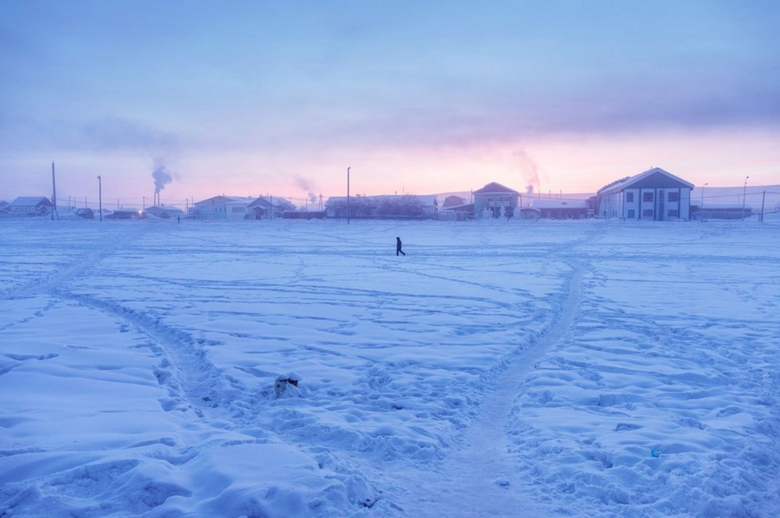A man walks in the village at sunrise. The climatic factor is here omnipresent: in February 1892, the lowest temperature in the world (Antarctica not included) was recorded in Verkhoyansk. And if the village is fighting over the title of the coldest village in the world with Oymyakon, it nevertheless holds the record of the greatest temperature range on Earth: 105°C (189°F) with -67,8°C in winter and 37,3°C in summer.