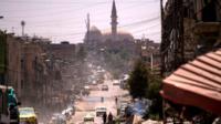 Cars drive along a damaged street in western Mosul on 12 July 2017