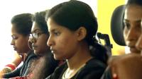Women at computer screens in an office in India