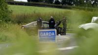 Garda (Irish police) examine one of the three vehicles involved in the crash