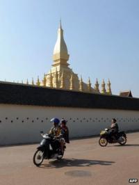 Motorcycle riders in front of the That Luang stupa in Vientiane