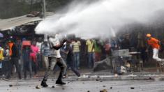 A supporter of Kenyan opposition leader Raila Odinga is sprayed with water by police in Nairobi, Kenya on 17 November 2017