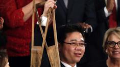 Ji Seong-ho enarbola sus muletas al ser reconocido en el discurso del Estado de la Unión.