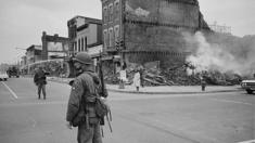 Un soldado frente a un edificio destruido