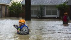 Un rescatista camina por la parte oeste de Houston buscando a personas que puedan estar varadas en sus casas.