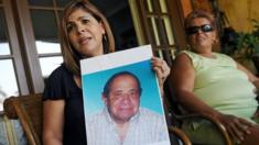 Mitzila Donado (izquierda), junto a su madre Rudecinda Delgado, sostiene una foto de su padre, Jaime Donaldo, quien murió en 2006 tras haber tomado el "jarabe de la muerte". Imagen tomada el 25 de marzo de 2009 en Ciudad de Panamá. (Foto: Elmer Martínez / AFP / Getty Images)