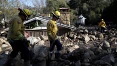 Firefighters search for people trapped in mudslide debris on January 10, 2018 in Montecito, California.
