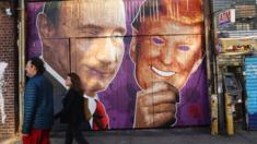 A mural depicting a winking Vladimir Putin taking off his Donald Trump mask is painted on a storefront in Brooklyn, New York.