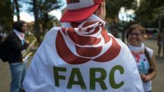 Un simpatizante de la FARC envuelto en la bandera con el logo del nuevo partido en el cierre de su congreso en Bogotá.