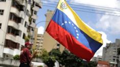 Hombre sosteniendo la bandera de Venezuela en Caracas.