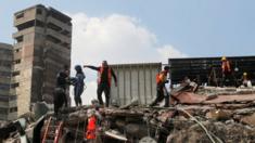 Miembro de los equipos de rescate dando órdenes mientras se retiran escombros de un edificio en busca de supervivientes.