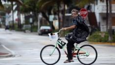 Un hombre pasea en bicicleta por Miami Beach.