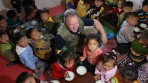 David Beasley surrounded by children in North Korea