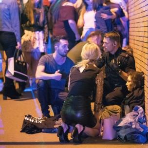 Police and other emergency services are seen helping the injured near the Manchester Arena after an explosion.