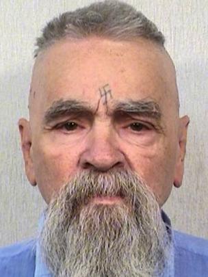 Charles Manson já com idade avançada, com suástica na testa.
