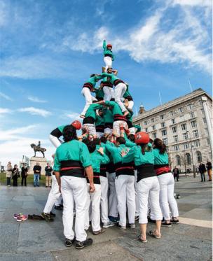 A tower made out of people standing on each other's shoulders