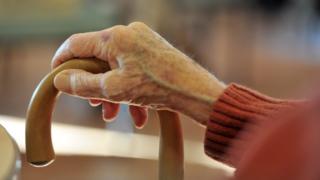 elderly person with walking stick
