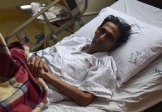Mansoor Ahmed lying on his hospital bed in Karachi.