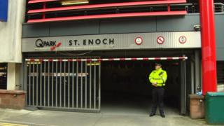 Police officer at entrance to car park